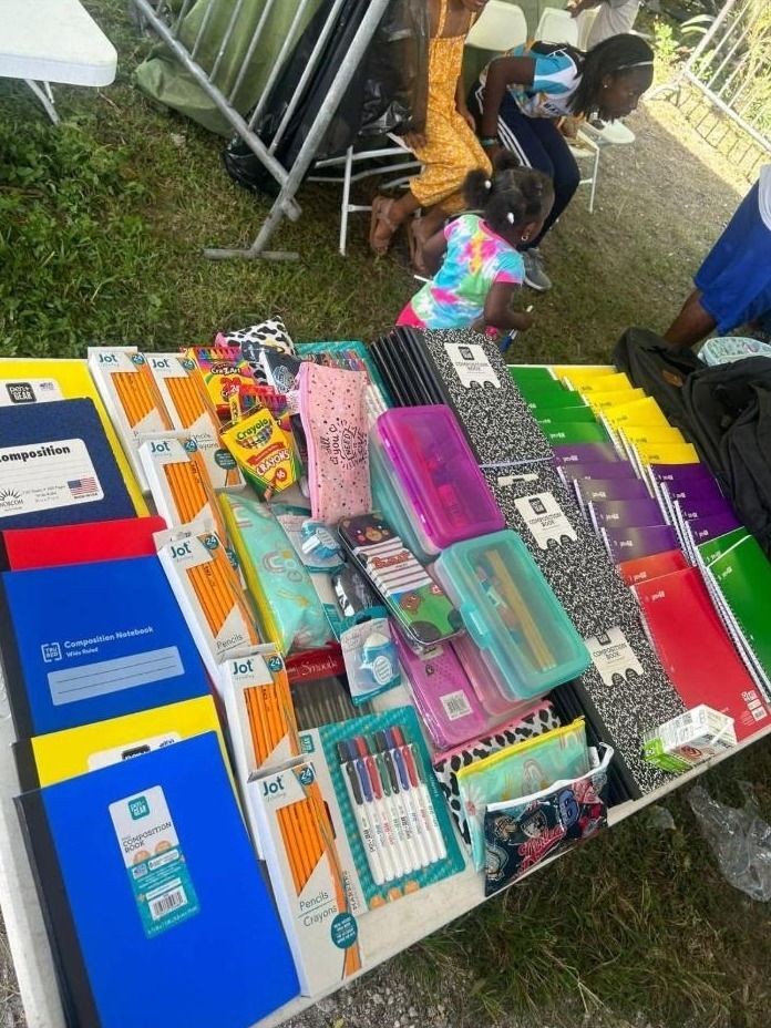 Composition books, pencils, crayons, pencil cases and notebooks laid out on a table as school supplies